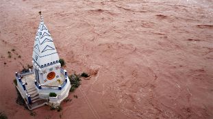 Der kleine Tempel steht mitten im Wasser des überfluteten Flusses Tawi in Jammu, Indien. Heftige Regenfälle haben den Fluss übers Ufer treten lassen.