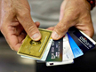 United States, Miami: Alain Filiz shows off some of his credit cards as he pays for items at Lorenzo's Italian Market on May 20, 2009 in Miami, Florida. (AFP Photo / Joe Raedle)